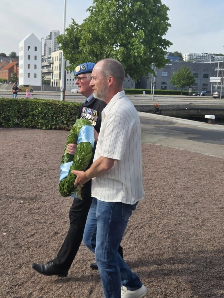 Kransen bæres ind til Mindestenen af byrådsmedlem Jesper Gade og formand Hans Christian Mortensen.